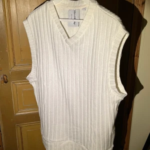 Stickad väst - Vit stickad väst. Sitter lite oversized. Köpare står för frakt.