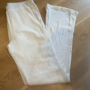 Ett par vita ribbstickade byxor med lite  bootcut från ginatricot i st M. Dom är i bra skick och använda få gånger. Nypris 250kr