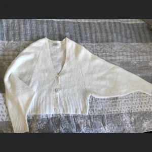 Vit tröja med knappar  - En oanvänd vit stickad tröja med knappar från Gina Tricot stl S