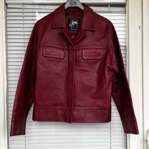 RÖD LÄDERJACKA - Supersnygg röd läderjacka (äkta läder) säljes. Inga skavanker eller dylikt, toppen skick. Strl: L, men kan bäras som one size<3 kan skicka bild på hur den sitter. 