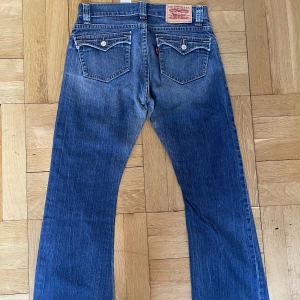 Lågmidjade vintage Levi’s-jeans - Säljer de här sjukt snygga, lågmidjade vintage levi’s-jeansen i bootcut med unika fickor!  Köparen står för frakten💕 Midjemått: 80 cm Innerbenslängd: 72 cm