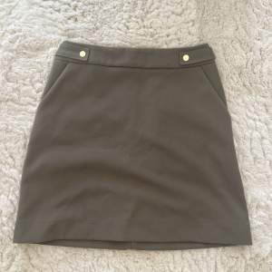 Mörkgrön kjol från H&M i storlek 38💚 Aldrig använd, enbart testad! Guldiga knappar som detaljer, har även fickor. 