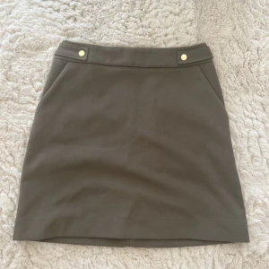 Mörkgrön kjol - Mörkgrön kjol från H&M i storlek 38💚 Aldrig använd, enbart testad! Guldiga knappar som detaljer, har även fickor. 