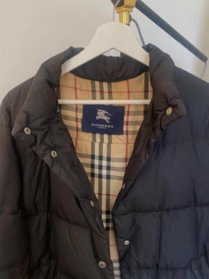 Burberry vinterjacka - Säljer denna burberry jacka💕 sitter bra på mig som är 174 och brukar ha storlek S💕 tunn luva som man kan sätta på medföljer!