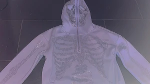Rhinestone Zip hoodie - En super cool Y2K hoodie som du kan stänga upp till huvudet. Med rhinestones med döskalle inslag på ärmarna och kroppen osv. Använd cirka 2 gånger, som ny. Inga defekter. Köpt för 600 på fruugo. 