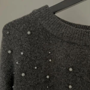 Stickad tröja - Stickad tröja med pärlor på framsidan. väl använd men i bra skick.