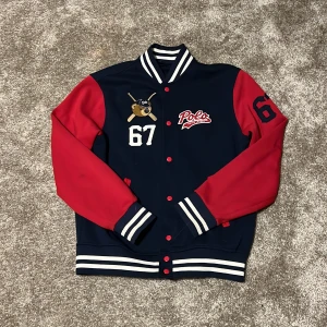Collegejacka från Polo Ralph Lauren - Collegejacla från Polo Ralph Lauren. Köpt i Danmark 2019 och har knappt använta något. Mycket bra skick bortsett från en liten liten fläck som jag inte närkt förens jag tog bilderna nu (se bild 2 baksidan av ärmen till höger). Nypris 1500 svenska kr. 