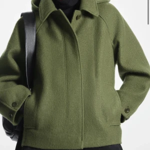 Cos jacka - Säljer min fina jacka från Cos! Super fint skick och endast andvänd ett få tal gånger! Super skön med luva och till vintern! SLUTSÅLD