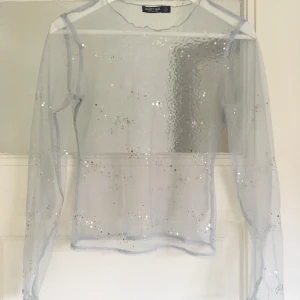 Glittrig mesh tröja ❄️❄️ - Superfestlig glittrig topp. Ljust blå med silver-paljetter, fin layering piece ✨✨Några av paletterna har lossnat.   Frakt 12 kr. 