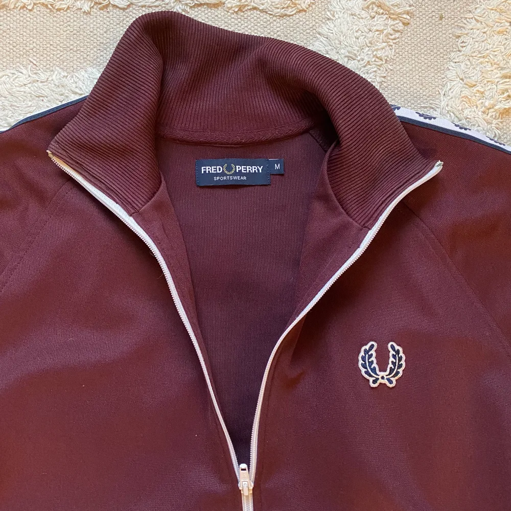 Sjukt fet tracktop från fred perry. Färgen är vinröd. Storlek M och passar perfekt på mig som är 180cm/76kg. . Hoodies.