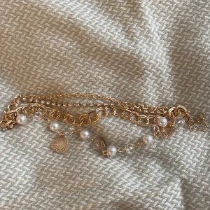 Guld armband - Super gulligt armband med 4 länkar. Innehåller vita och genomskinliga pärlor, guldiga hjärtan och diamanter. Säljer pga att jag gått över till silversmycken! 💓Gratis frakt💓