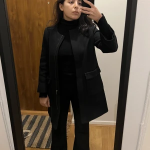 Svart rak kappa - Jättefin kappa i rak modell. Minimalistisk men riktigt klassisk med fina detaljer. Köpt från MANGO i storlek XS men passar nog även S