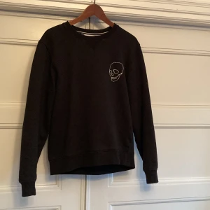 Custom Lacoste kofta - Lacoste tröja med påsydd dödskalle. Använd men i väldigt bra skick.