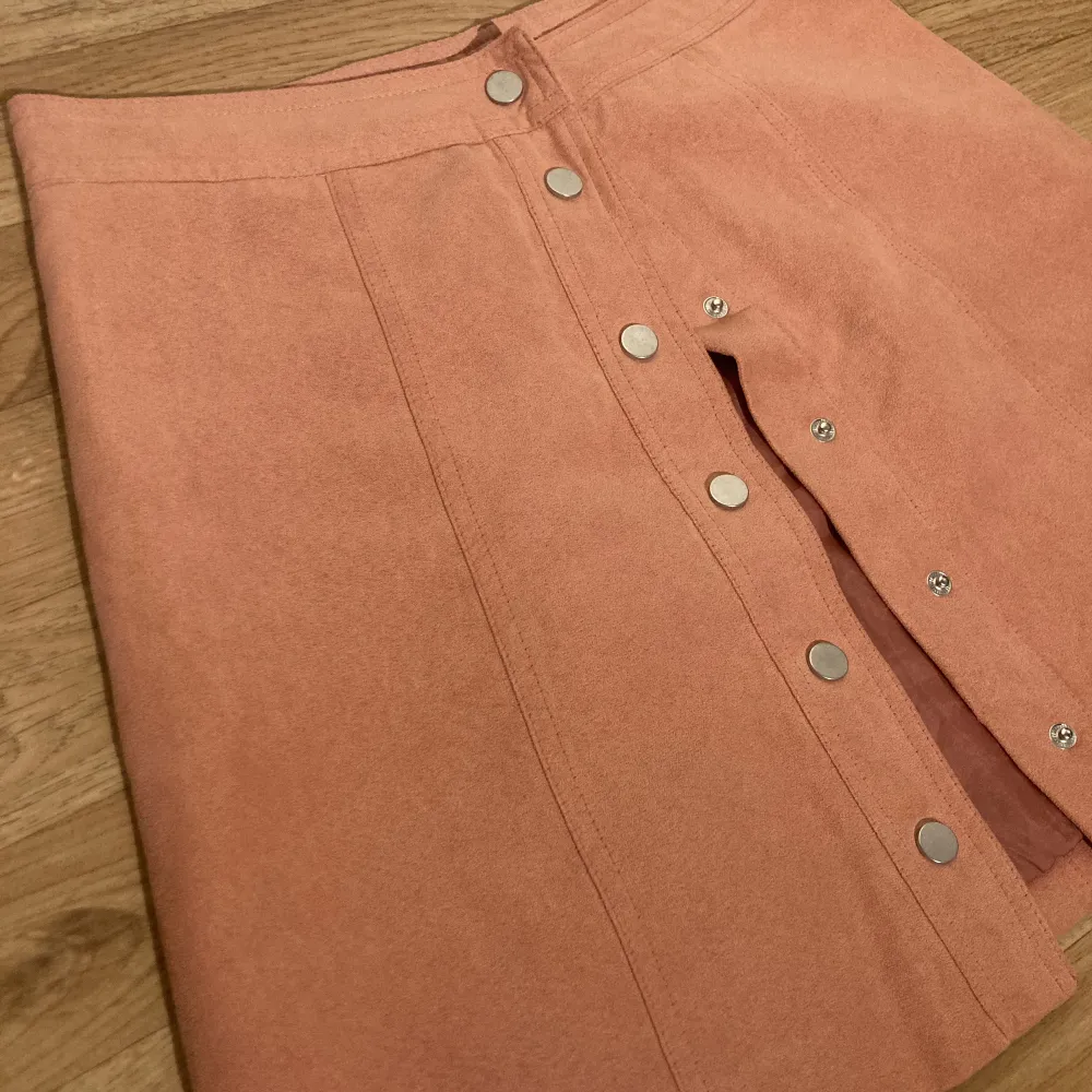 En rosa kjol med knappar, den är använd ett fåtal gånger! Väldigt bra skick. Kjolar.