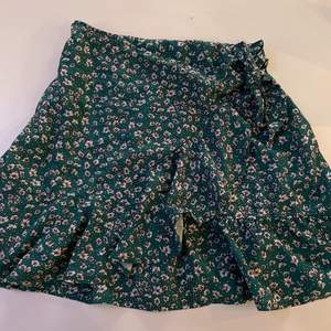 Säljer denna gröna blommiga kjol perfekt nu till sommaren. Den går att knyta som ni ser på andra bilden.