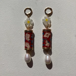 Örhängen  - Droppörhängen i färgen ”vermilion”. Material: 40% zink, 35% färskvatten pärla, 13% brass, 10% plast, 2% stål. Längd: 8 cm.  Frakt: 12 kr