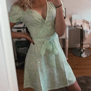 Grön klänning - Säljer denna super gulliga gröna klänning med vita små blommor på. Bara använd på en skolavslutning. Den är från Gina tricot. 