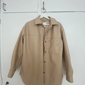 Beige Skinn Skjorta från HM - Beige skinnjacka eller skinnskjorta inköpt förra året, enbart använd 1 gång!