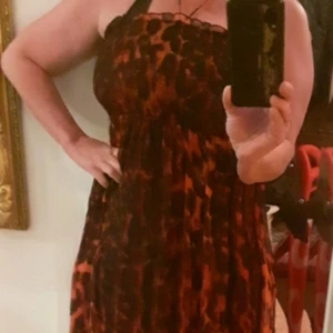 Superfin svart&röd klänning - Superfin svart&röd  leopardmönstrad långklänning.Den har slits på båda sidorna,bra kvalitet jättefin på sommaren.Storlek: M.Har aldrig varit använd.Skickar gärna om köparen betalar frakt 59kr.