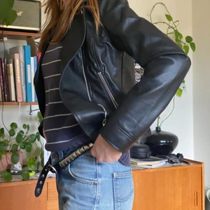 Svart Skinnjacka - Svart skinnjacka från hm, köptes förra året, använd ett fåtal gånger och är i väldigt bra skick. passar xs-s.