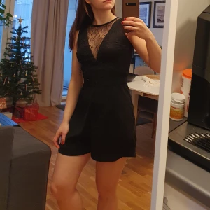 Svart byxdress  - Den perfekta nyårslooken! En svart playsuit med spettsdetaljer 🖤  Använd en gång så i bra skick! Ända anmärkningen är ett litet hål under bandet i ryggen (se bild) dock syns detta inte när man har på sig byxdressen och går nog lätt att sy igen.