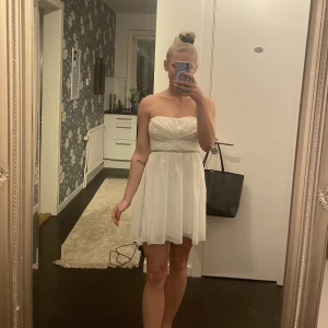 Klänning  - Vit klänning med glitter detalj på. 