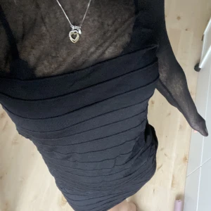 Klänning - Svart klänning med ”ränder”, mesh-tyg högst upp samt vid armarna. Vet inte vart den kommer ifrån då jag ärvt den, bra skick! 