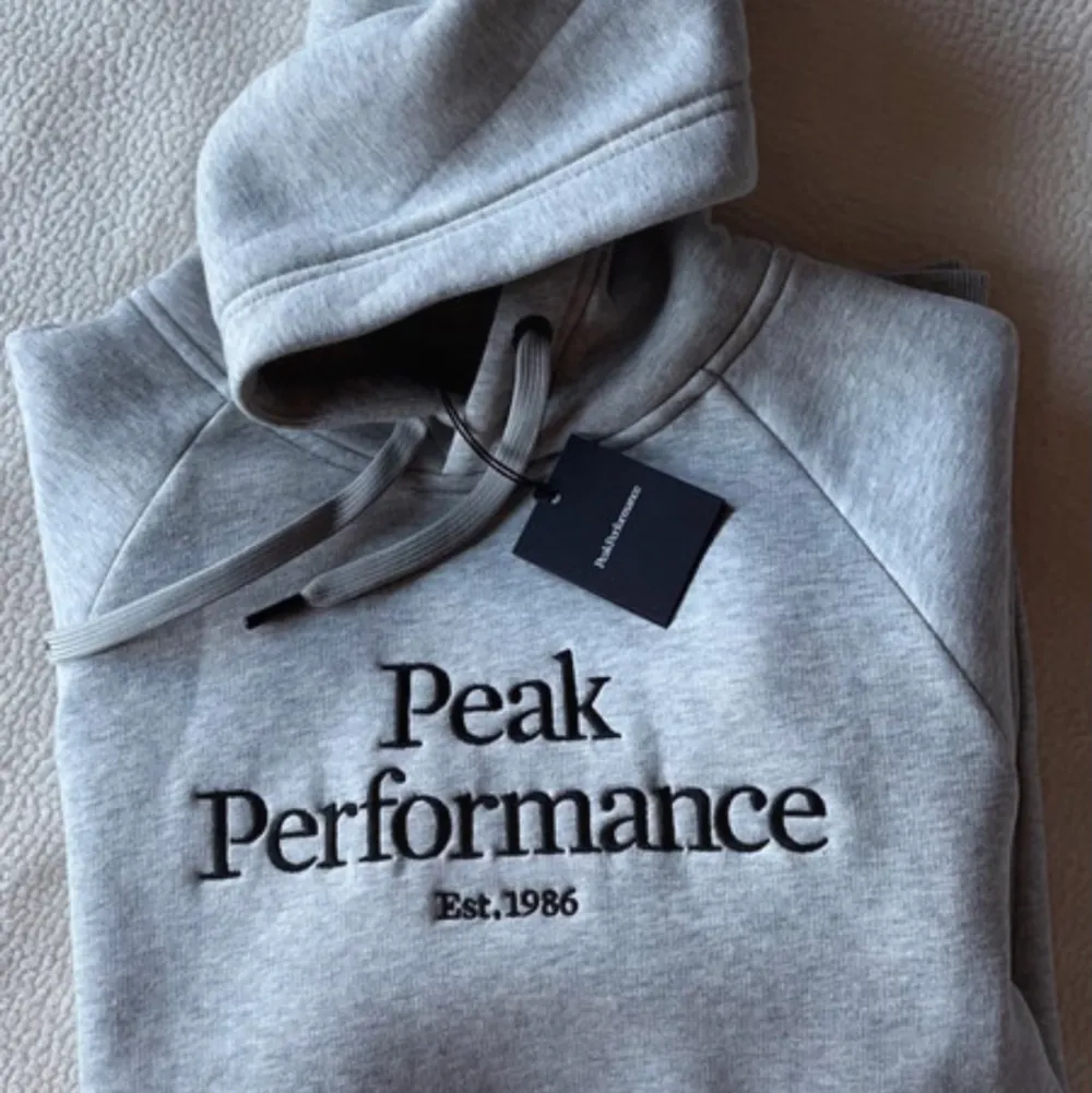 Oanvänd hoodie från Peak Performance med prislappen kvar! En grå hoodie i storlek S som aldrig kommit till användning! Pris kan diskuteras! Frakt ingår i priset!. Hoodies.