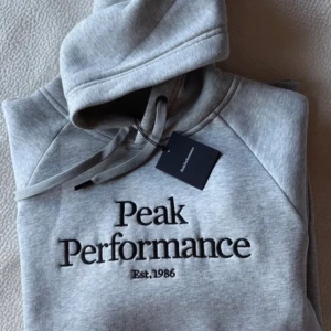 Peak Performance Hoddie - Oanvänd hoodie från Peak Performance med prislappen kvar! En grå hoodie i storlek S som aldrig kommit till användning! Pris kan diskuteras! Frakt ingår i priset!
