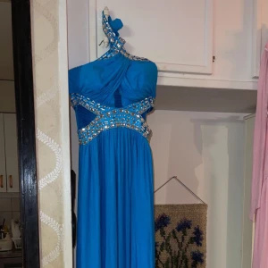 Blå maxiklänning  - En helt oanvänd blå maxiklänning köpt från London. Har kristallpärlor på bandet. Passar perfekt för kväll, fest, bröllop och speciella evenemang. 