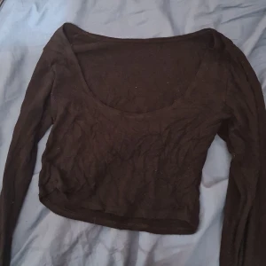 Långärmad - Den är kort, men långa ärmar och man kan ha uringningen framlänges eller bakåt så den visar mer rygg. Väldigt stretchig