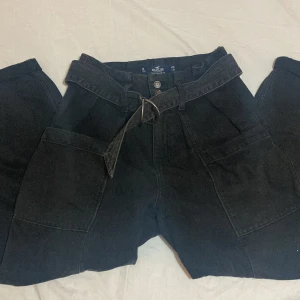 Cargobyxor från Hollister, 36 - Svarta cargobyxor från Hollister. Väldigt sköna byxor, endast använda fåtal gånger. Det finns ett skärp till byxorna, som sett på bilden🃏