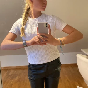 Zara topp med pärlor - As snygg vit, lite tjockare topp från zara. Den är ribbad och har vita ”sötvattenspärlor” på framsidan. Jätte fint skick!🐚💫