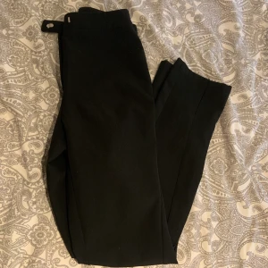 Kostymbyxor  - Svarta kostymbyxor aldrig använda då de inte passar. De var en svart slits längst ner vid foten.