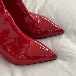 Lackade Röda klackar - Röda lackade boots i rött från Tamaris. Ser helt orörda ut pga använda en gång.