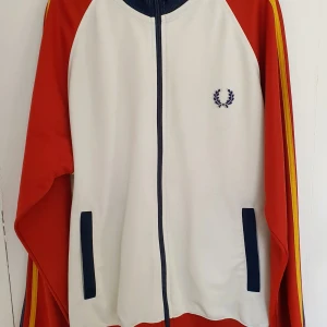 Fred Perry träningsjacka - Fred Perry träningsjacka i retrostil. Mycket bra skick och fina färger. Herrstorlek S.