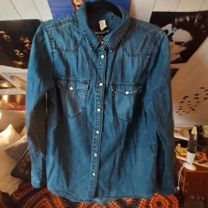 Blå jeansskjorta - Fin jeansskjorta med vita knappar i bra skick! Köpt second hand men aldrig använd av mig.  Står ej för frakt🧡
