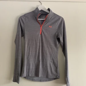 Träningströja från Under Armour - Grå träningströja från Under Armour. Storlek Xs men passar även som S. Litet hål på högra armen men syns knappt. Skriv för fler bilder