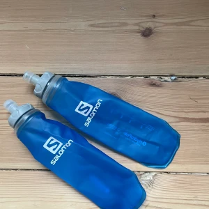 Salomon löparväst - Grym löparväst! Smarta fickor på fram- och baksida. Passar XS-L då en kan reglera spännena precis som du själv vill. Säljer även vattenflaskor från Salomon som passar i fickorna på framsidan. 