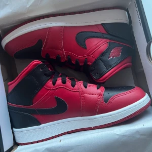 NIKE JORDEN 1 Mid White/Black/Gym Red - Helt ny Jorden som är köpta från restocks, men alldeles för stora för mig så väljer att sälja det här. Men som sagt är de helt nya och är i storleken 37,5. Säljer de för 2500kr.