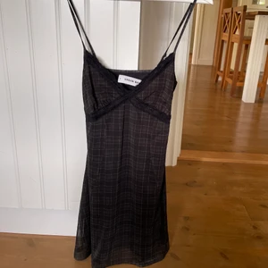 Klänning UO - Svart & mörkgrön-rutig klänning från Urban Outfitters. Lappen sitter kvar, nypris 550kr.