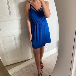 Blå klänning i storlek M - Vad:En skir kornblå klänning med öppen rygg. Storlek: M  Skick: Utan anmärkning 