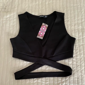 Svart Crop Top - Säljer fin svart festtopp från Boohoo i storlek 40 🖤✨ Har aldrig använt den ☺️ Säljer den för 35kr+frakt 💕 Dm för mer info/bilder ☺️