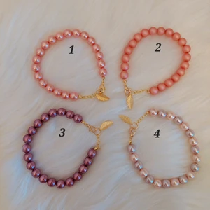 Handgjorda pärlarmband  - Handgjorda pärlarmband med lövhänge i guld.