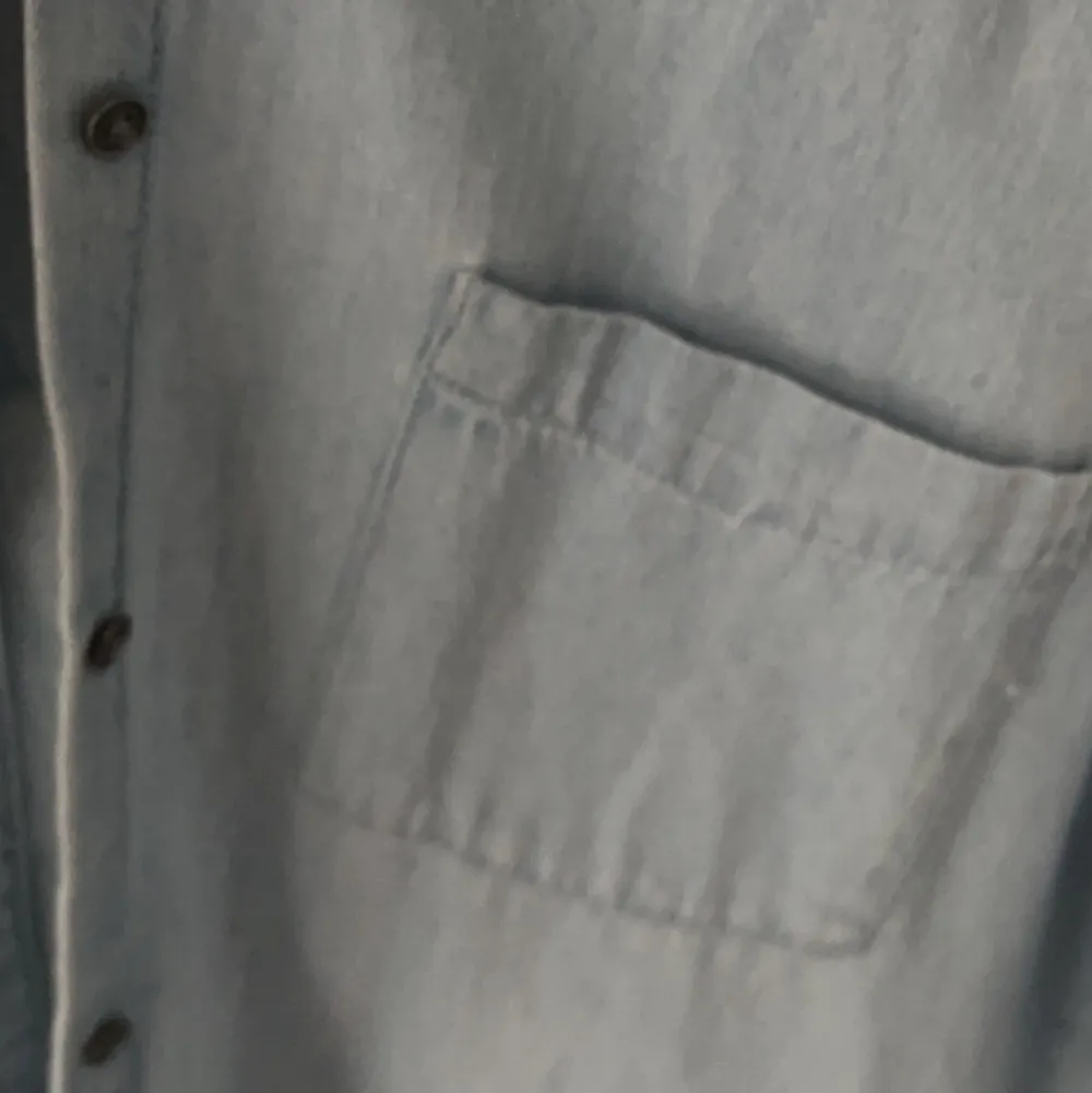 En ljusblå jeansskjorta från Lindex i bra skick, inga defekter. Passar mig som har storlek XS, är lite oversized på mig. Säljer pga att den inte kommit till användning. Jätte fin till en sommarklänning. Köparen står för frakt. . Skjortor.
