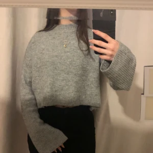 Stickad tröja  - Grå lite kortare stickad tröja med vida ärmar 