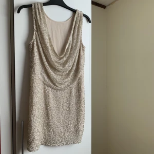 Paljetter öppen rygg klänning - Klänning med paljetter och öppen rygg. Nude färg med silver pärlor. 