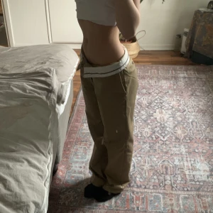 Lågmidjade kostymbyxor beigea - Nyköpta kostymbyxor från H&M i strl 36🫶 Dem går ner till marken på mig som är 162. Vet inte om det är menat att man ska vika ner midjan som jag gjort på bilden men jag tycker det ser bäst ut iaf men man gör som man vill❤️ 