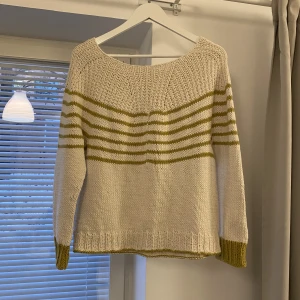 Stickad tröja - Stickad tröja i en crémevit färg med gröna ränder och detaljer. Fint skick. Ser ut att vara handstickad men vet ej om den är det. Köpt secondhand. Passar xs och s💓
