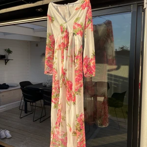 Playsuit med ”släp”  - Blommig Playsuit med shorts och tyg hängandes bakom. Använd en gång sen har den hängt på en galge.  Storlek S för liten för mig då jag mestadels har M